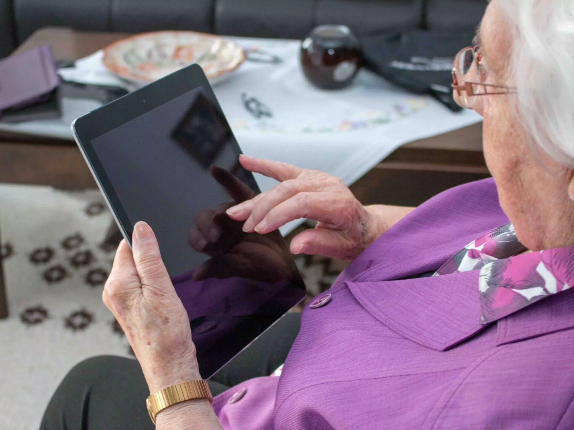 Alte Frau schreibt auf einem Tablet PC